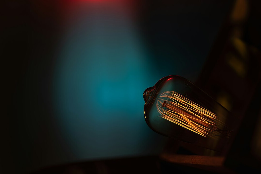 Old cathode ray tube television glowing with colourful static in a dark room